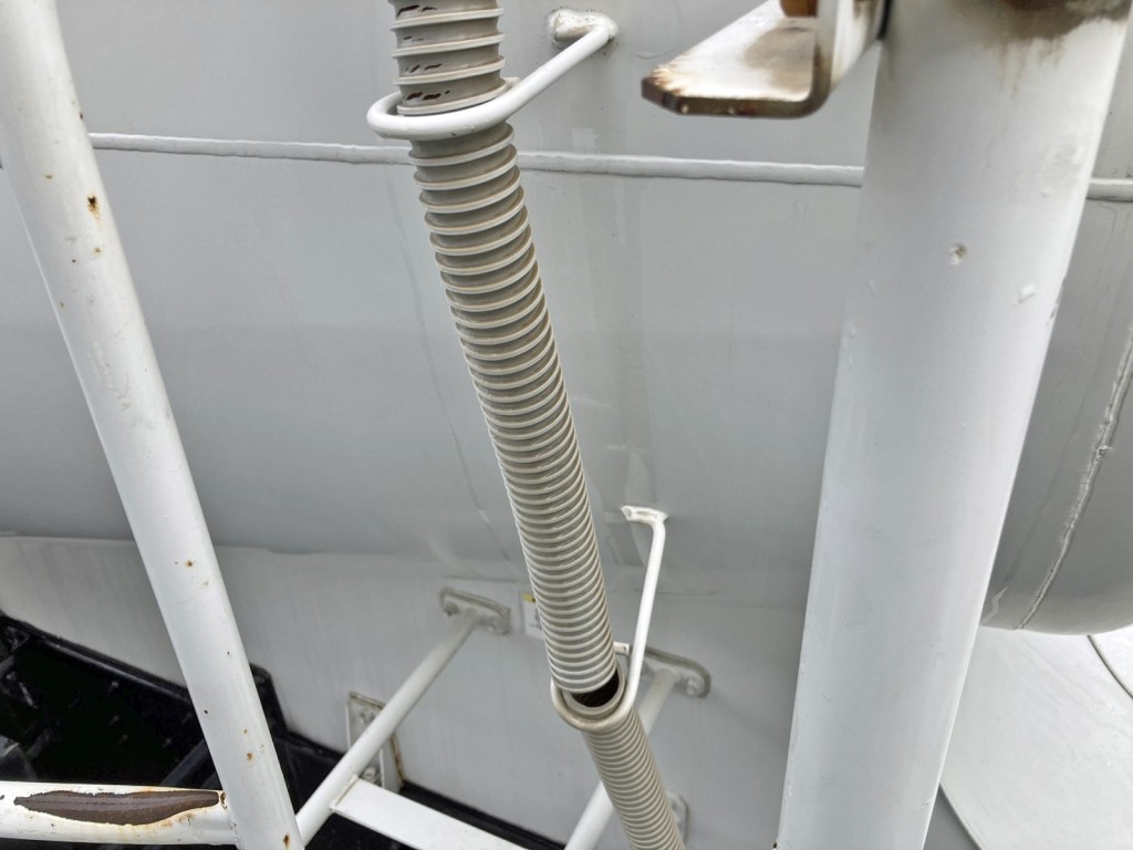 タンク運転席側前方下部の水抜きホースに破れがあります。|いすゞ ギガ KL-CYL23Q4の写真33